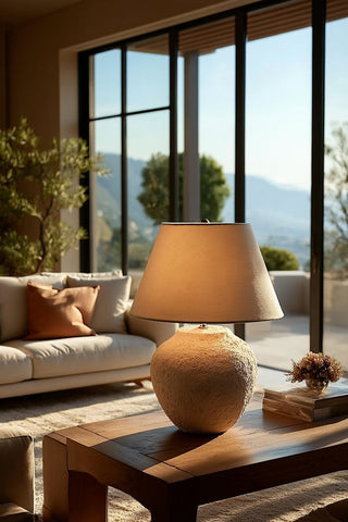 A warmly lit ceramic lamp on a console table