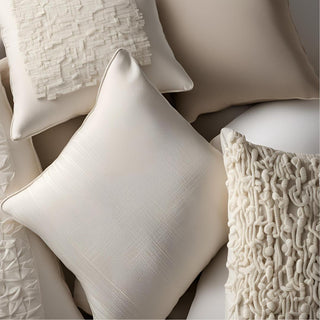 Multiple throw pillows in varying colors of neutrals and textures such as velvet, boucle, linen and cotton