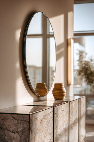 Round mirror on a mantel with decor