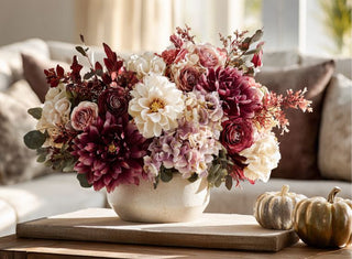 A fall inspired True Bloom floral arrangement styled on a modern transitional coffee table with complementary home decor items