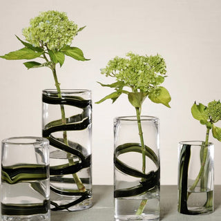 Smoked Olive Ribbon Glass Vase styled with green hydrangea stems, showing clear glass, smoked olive ribbon movement, and a tall sculptural shape.