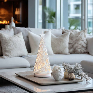 White laser cutout LED water spinning tree glowing softly on a marble coffee table in a cozy neutral living room with warm holiday décor, creating an elegant and inviting ambiance.