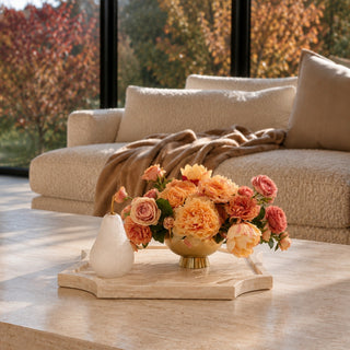 14 Inch white travertine stone tray styled on a living room coffee table with decorative pears and a warm floral arrangement.