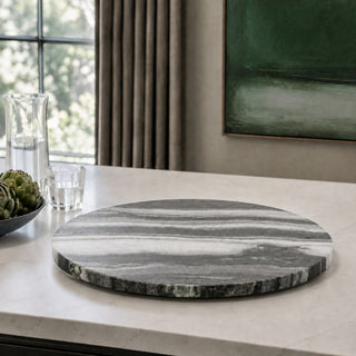 16 Inch Black & White Swirled Marble Lazy Susan styled on a light stone kitchen island, showing the natural gray, black and white marble veining.

