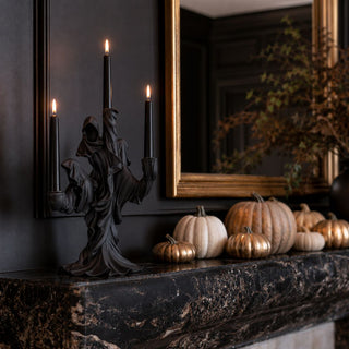 17.5-inch black draped ghost three-taper candle holder styled on a black marble mantel with fall pumpkins