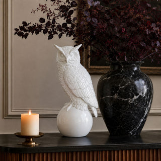 18.25 inch glossy white resin owl sculpture styled on a dark console with a black marble vase, candle, and burgundy fall branches for Halloween decor.