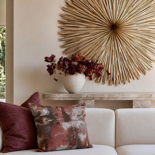 20-inch Albion abstract throw pillow styled on a cream sofa with merlot pillows, featuring terracotta, sienna, umber, stone, and gray tones.
