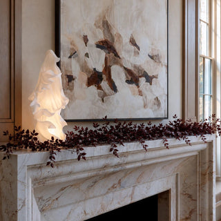 Styled 24.25 inch white draped LED ghost in matte resin with warm interior glow on a marble mantel with burgundy foliage for Halloween home decor.