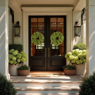 Green faux hydrangea wreath with full realistic blooms and soft natural texture, styled as a classic decorative accent placed on a double door front entrance