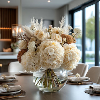 27.5 styled light cream faux hydrangea stem in a round glass vase with other fall inspired florals on the table in a luxury decor style dining room 
