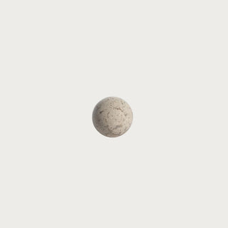 Small 3-inch natural travertine stone decorative orb with warm cream-beige coloring, mineral markings, and organic surface variation.