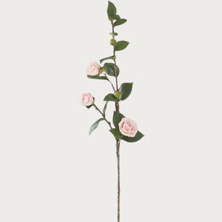 30 inch faux pink camellia stem with blush layered bloom and green leaves on white background
