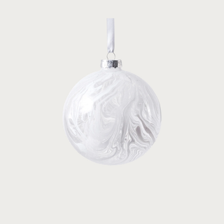 Large white watercolor glass ornament hanging on Christmas tree in bright living room with soft neutral décor – modern handcrafted glass holiday ornament with luminous finish.