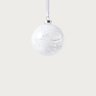 White watercolor glass ornament with satin ribbon displayed on Christmas tree in bright living room – sophisticated winter-white holiday décor accent.
