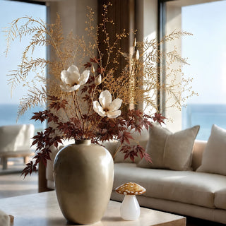 Small 5.5-inch amber, gold and white speckled glass mushroom styled beside a large vase and autumn floral arrangement on a neutral coffee table.