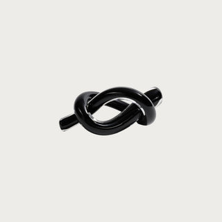 6.25-inch obsidian black glass knot sculpture with glossy intertwined loop form and sculptural decorative silhouette.