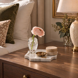 Small 6.75-inch natural Volakas marble tray with soft gray veining and satin finish, styled on a wood bedroom dresser with a crystal bud vase, jewelry dish, and stone decorative box.