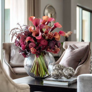 A beautiful floral arrangement of Fuchsia calla lillies and other florals in a vase on a table of  contemporary decor style living room with soft-touch petals and green stems – styled for home decor by Third & Main