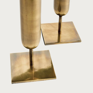 Close-up of the set of two antiqued brass iron vases showing their narrow stems, warm metal finish, and square bases.