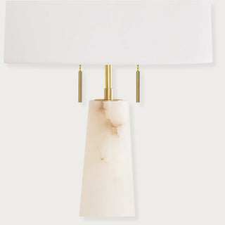 Luxury alabaster stone table lamp featuring a sleek conical silhouette, natural brass finish, and crisp white shade for elegant lighting. Home Decor, Third & Main, alabaster table lamp, modern table lamp, alabaster stone lighting, brass table lamp, bedside lighting, contemporary lamp, Luxury decor
