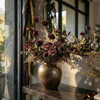 Beautiful styled photo of a luxury modern contemporary decor style home with the burgundy  flower stem and other complementary florals in a vase on an entryway  console table 