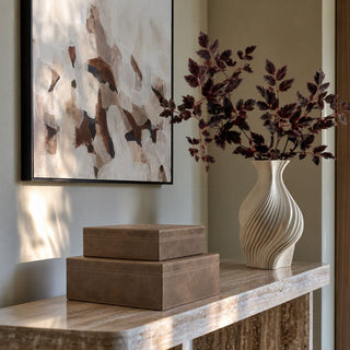 Belmont Mink Brown Leather Boxes styled on a stone console with abstract art, a cream fluted vase, burgundy branches, and warm contemporary decor.