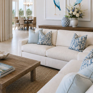 A bright coastal living space layered with soft blue accents, collected ceramics, warm natural textures, and ocean-inspired artwork for an effortlessly elevated beach house aesthetic.