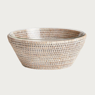 handwoven rattan serving bowl with glass insert in warm gray tone styled on kitchen table with fruit
