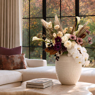 Autumn Champagne Floral Bundle styled in a frosted taupe glass vase with creamy orchids, champagne calla lilies, plum blooms, pampas, blackberry stems, and magnolia leaves.