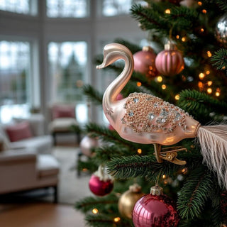Close-up of delicate glass clip-on swan ornament with blush tones and gold beading, perfect for holiday tree styling or sophisticated home décor accents.