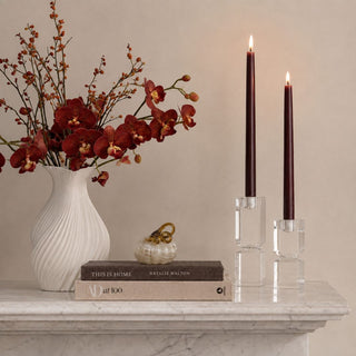 3.25 Inch Cream & Gold Swirl Glass Pumpkin styled on books beside burgundy taper candles, crystal candleholders, fall branches, and a white ribbed vase on a marble mantel.