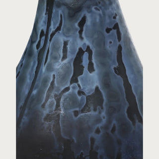 Close-up of the hand-cut textured surface on a deep blue glass pear sculpture showing irregular midnight blue and near-black tonal variation.