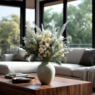 Dusty lavender and soft green real touch floral arrangement styled in a ceramic vase on a modern coffee table with natural light