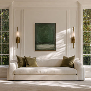 Evergreen Horizon green abstract canvas styled above a cream sofa in a light living room with olive pillows and brass wall sconces.