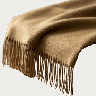 Close-up of the Honey baby alpaca throw showing its soft brushed texture, warm camel-gold color, woven surface, and tonal fringe.