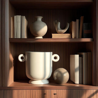 Large white ceramic planter with loop handles styled on a dark fluted wood hutch shelf, paired with neutral books and sculptural ceramics in soft morning light