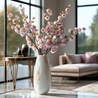 23.5-inch True Bloom light purple real touch blossom stems arranged in a tall ivory vase on a marble surface in a modern contemporary living room with floor-to-ceiling windows and soft natural light.