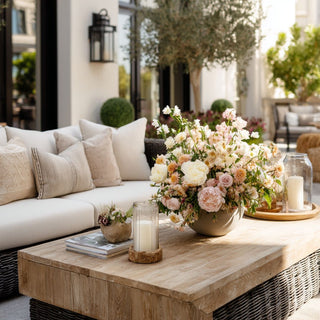 Light_Real_Touch_Pink_Lisianthus_Stem and other spring and summer florals in a floral arrangement on an outdoor coffee table of a beautifully decorated patio setting.
