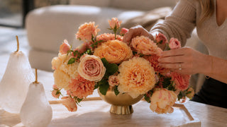 a woman's hands re-arranging a pre-made floral arrangement full of luxury faux florals
