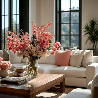 Luxury modern living room with pink spring floral arrangement styled on a wood coffee table in natural light

