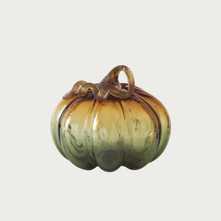 Medium ombre green and amber glass pumpkin measuring 6 inches high by 6.25 inches wide with transparent ribbed glass and brown stem.