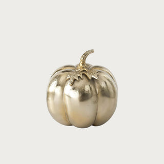 Medium soft matte gold aluminum pumpkin measuring 7.5 inches high by 6.5 inches wide with ribbed sides, sculpted leaf detail, and curved stem.