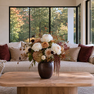 Medium dark brown mango wood vase styled with cream, camel, burgundy, and muted fall florals on a natural wood coffee table.