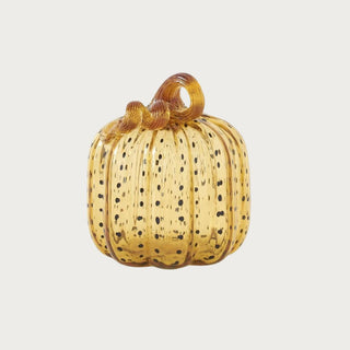 Medium 7.5 inch handblown golden amber glass pumpkin with scattered dark speckles, vertical ribbing and a curled glass stem.