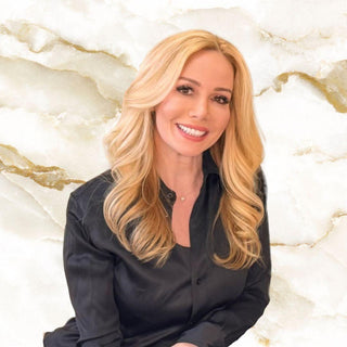 Meet the Team - Owner Mel, Woman with blonde hair smiling against a marble background