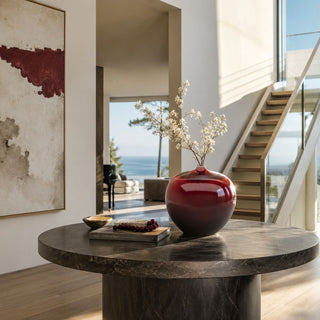 Merlot Gallery Vase in glossy merlot ceramic styled with delicate flowering branches on a round marble entryway table in a luxury contemporary home