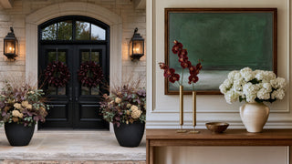Split view of modern traditional curated collection for fall 2026. Featuring tall gold single stem vases and dark merlot magnolia leave wreath