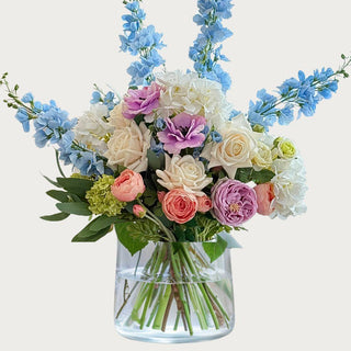 Morning Light True Bloom Real Touch Floral Arrangement - Multiple Options Available
Morning_Light_True_Bloom_Real_Touch_Premade_Faux Floral_Arrangement in a round cylindrical glass vase 
made with light purple buttercup. white peony, mini snowball stems, small oink roses, blue delphinium, light purple roses, cream roses and greenery. True Bloom Floral, Real Touch, Third & Main