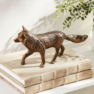Mr Fox 10-inch cast aluminum sculpture with an antique gold-bronze finish and detailed walking form, styled on stacked neutral linen books.