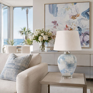 Nebula Blue Glass Lamp styled on side table in luxury coastal living room with soft blue accents ocean view and bright natural daylight